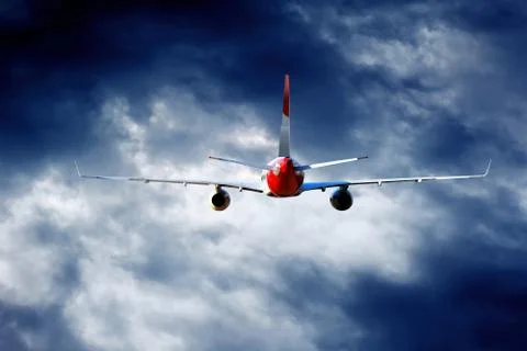 Airplane at fly on the sky with clouds Stock Photos