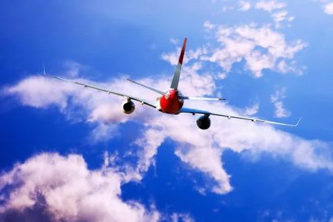 Airplane at fly on the sky with clouds Stock Photos