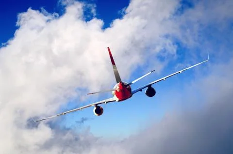 Airplane at fly on the sky with clouds Stock Photos