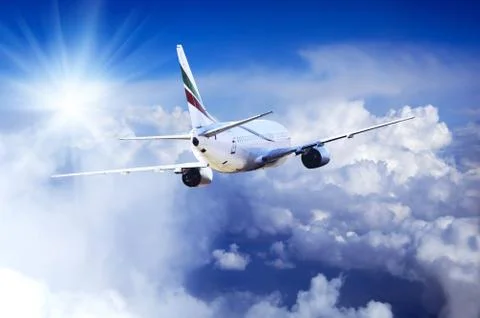 Airplane at fly on the sky with clouds Stock Photos