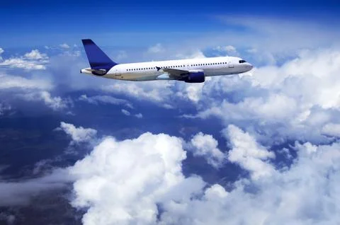 Airplane at fly on the sky with clouds Stock Photos