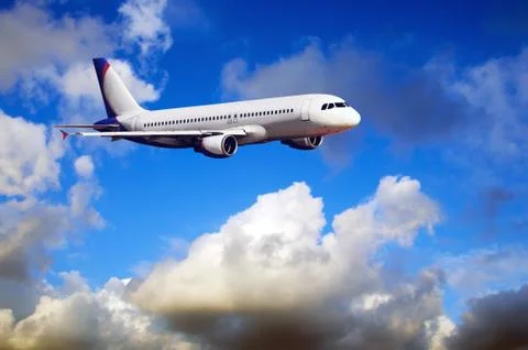Airplane at fly on the sky with clouds Stock Photos
