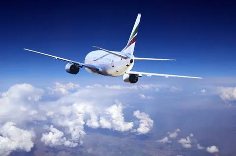 Airplane at fly on the sky with clouds Stock Photos