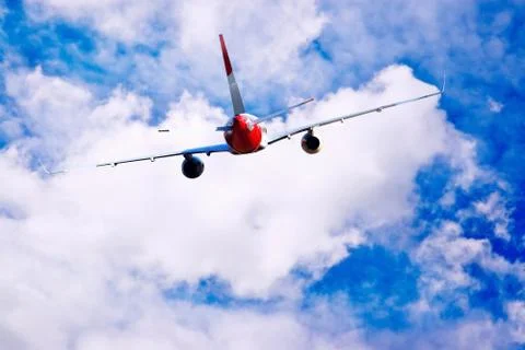Airplane at fly on the sky with clouds Stock Photos