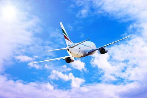 Airplane at fly on the sky with clouds Stock Photos