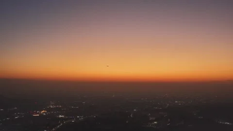 Airplane fly sunset sky over evening city. Plane flight, cityscape aerial view. Stock Footage 330519645