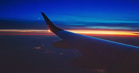 Airplane fly in sunset sky over earth of city light and wing of plane Stock Footage 336942513
