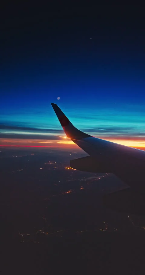 Airplane fly in sunset sky over earth of city light and wing of plane Stock Footage 336942772