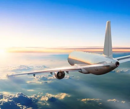 Airplane flying above clouds in dramatic sunset Foto stock