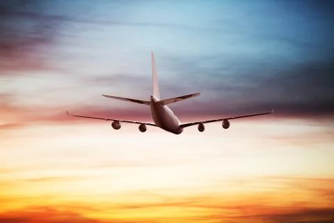 Airplane flying above dramatic clouds during sunset,sunrise. Stock Photos