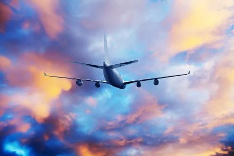 Airplane flying above dramatic clouds during sunset,sunrise. Stock Photos