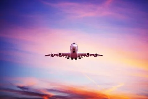 Airplane flying above dramatic clouds during sunset,sunrise. Stock Photos