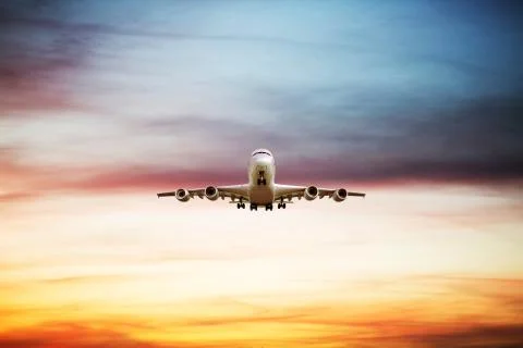 Airplane flying above dramatic clouds during sunset,sunrise. 스톡 사진