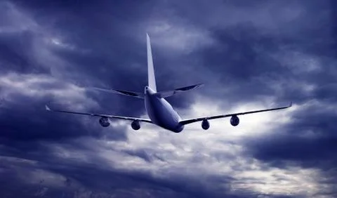 Airplane flying above dramatic clouds during sunset,sunrise. Stock Photos
