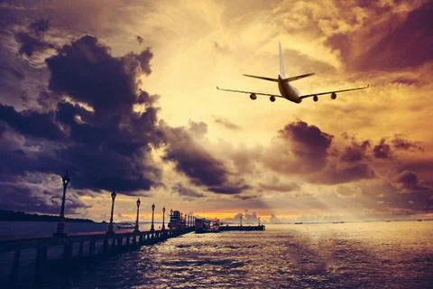 Airplane flying above dramatic clouds during sunset,sunrise. Stock Photos