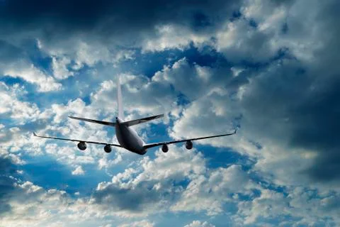 Airplane flying above dramatic clouds during sunset,sunrise. Stock Photos