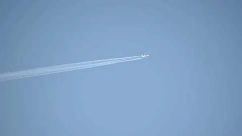 Airplane flying against blue cloudless sky leaving white contrail behind Stock Footage 193067044