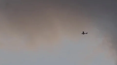Airplane flying against cloudy sunset sky Stock Footage 69142003