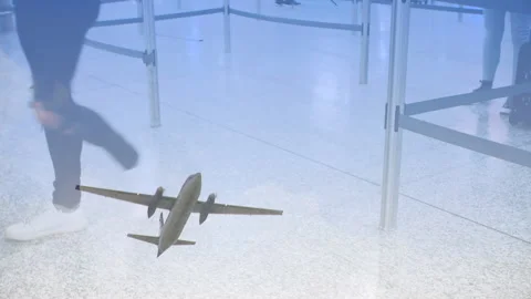 Airplane flying against low section of passengers walking in the airport Stock Footage 143956980