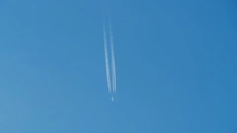 Airplane flying in clear blue sky leaving white contrails Stock Footage 345363687