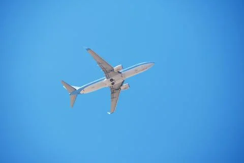 Airplane flying in clear cloudless blue sky Stock Photos