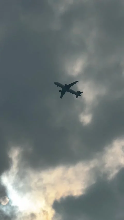 Airplane flying in cloudy sky over city in the afternoon Stock-Footage 332830434