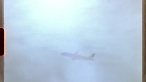 Airplane flying in a cloudy sky - super 8 mm Stock Footage 312414361