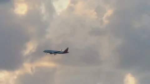 Airplane Flying in front of clouds at sunset 2 Stock Footage 162401847