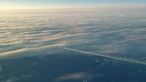 Airplane flying high above clouds with long white contrail from cockpit Stock Footage 277519747