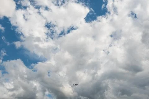 Airplane flying high in dramatic clouds Stock Photos
