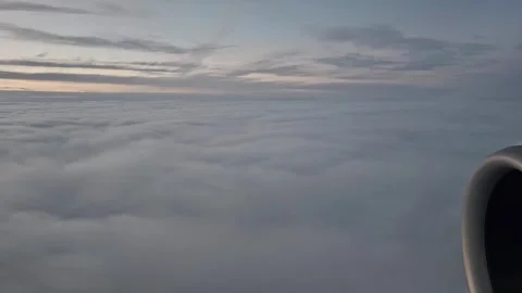 An airplane flying level with the clouds during a sunset flight over Europe. Vie Vídeo Stock 335317677