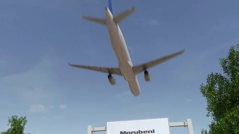 Airplane flying over advertising billboard with Marubeni Corporation logo Stock Footage