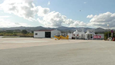 Airplane flying over an airdrome while another aircraft is taxiing Stock Footage 141773511