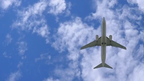Airplane flying over blue summer sky Stock Footage 79100749