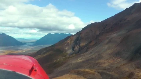 Airplane flying over the mountain range on a sunny day 库存影片 83304989