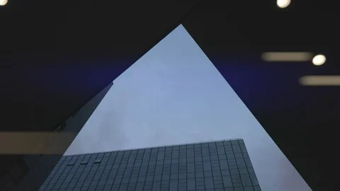 Airplane flying over skyscrapers and reflects in glass modern facades. Видео 113129448