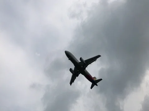 Airplane flying overhead against dramatic cloudy sky Stock Footage 79190994