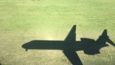 Airplane flying shadow touching down at airport runway 스톡 동영상 75288103
