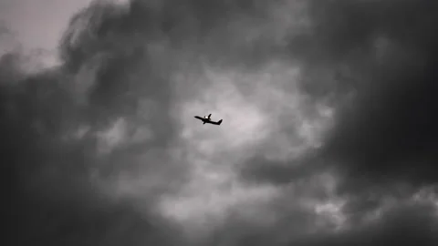 Airplane Flying Though Dark Clouds In Sky Above Akueyri Stock Footage 166643294