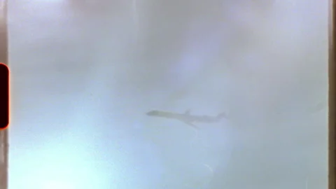 Airplane flying through clouds in vintage super 8 film look Stock Footage 312413237