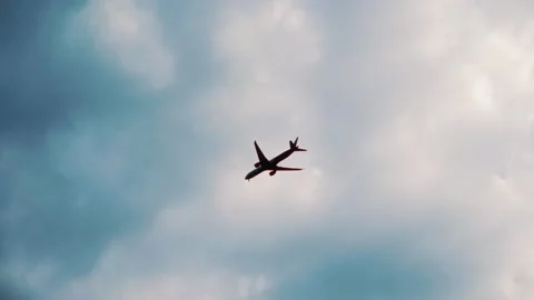 Airplane flying through cloudy sky, showcasing gradual ascent and movement, with Video stock 328481022