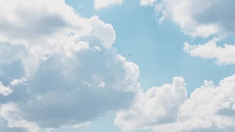 Airplane Flying Through Dramatic Blue Sky and Puffy White Clouds - Wide Stock Footage 340421304