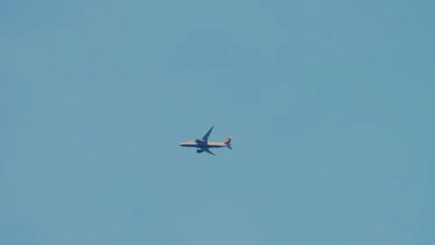 Airplane flying through evening sky at sunset light. Large cargo aircraft moving Видео 331160191