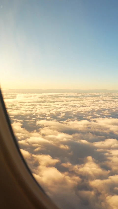 Airplane flying through white and golden clouds on a sunny day. Airplane window  Stock Footage 268447311