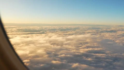 Airplane flying through white and golden clouds on a sunny day. Airplane window  Stock Footage 268447319
