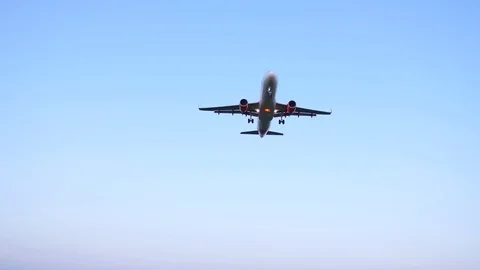 Airplane Flying Towards Camera & Overhead, Landing at Airport, Blue Sky Stock Footage