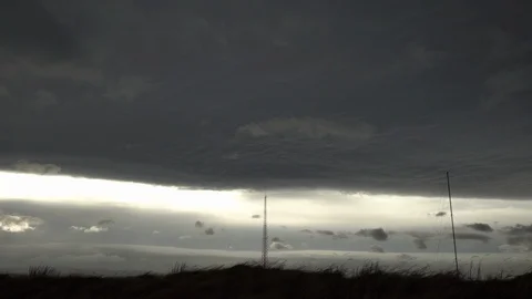 Airplane flying under dark storm clouds over radio transmitters Iceland Stock Footage 119956602