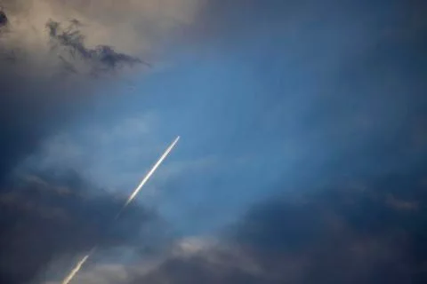 Airplane at flying under sky with clouds. Stock Photos