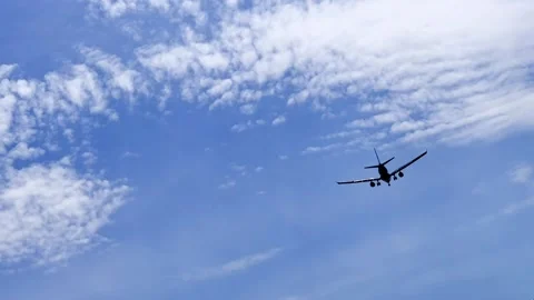 Airplane gaining height after taking off with a blue sky and clouds background Stock Footage 220090157