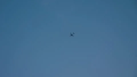 Airplane gliding through blue sky Stock Footage 293749220